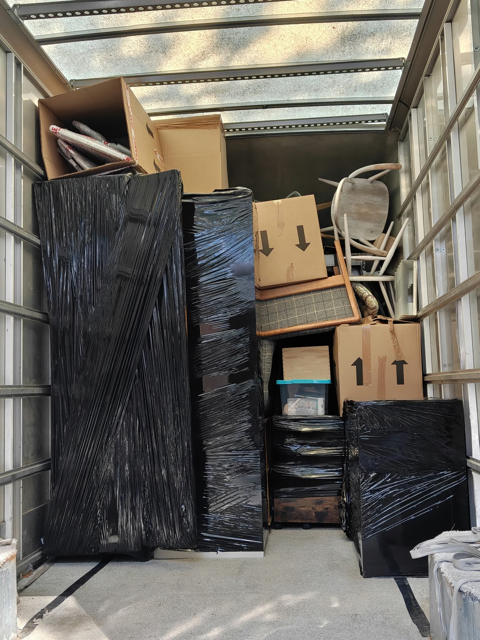 The van loaded — wrapped furniture strapped and stacked