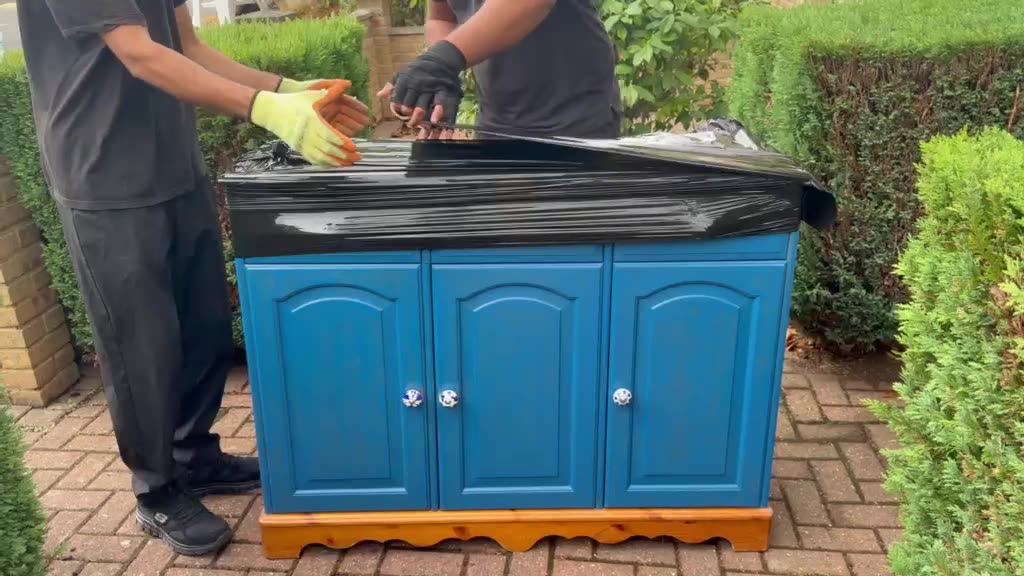 Two of the crew wrapping a sideboard before it is carried out